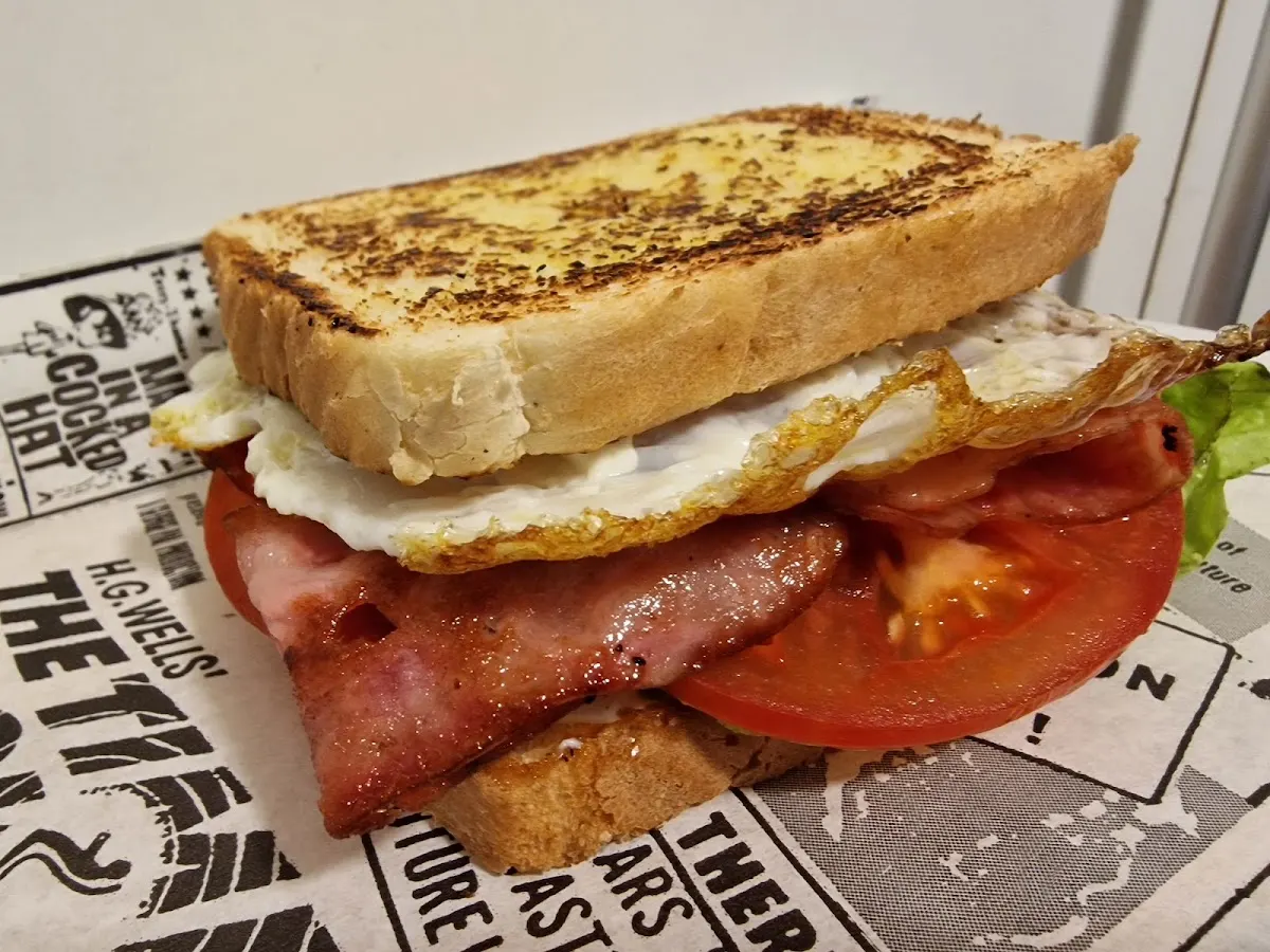 Sándwich tostado con huevo, bacon, tomate y lechuga.