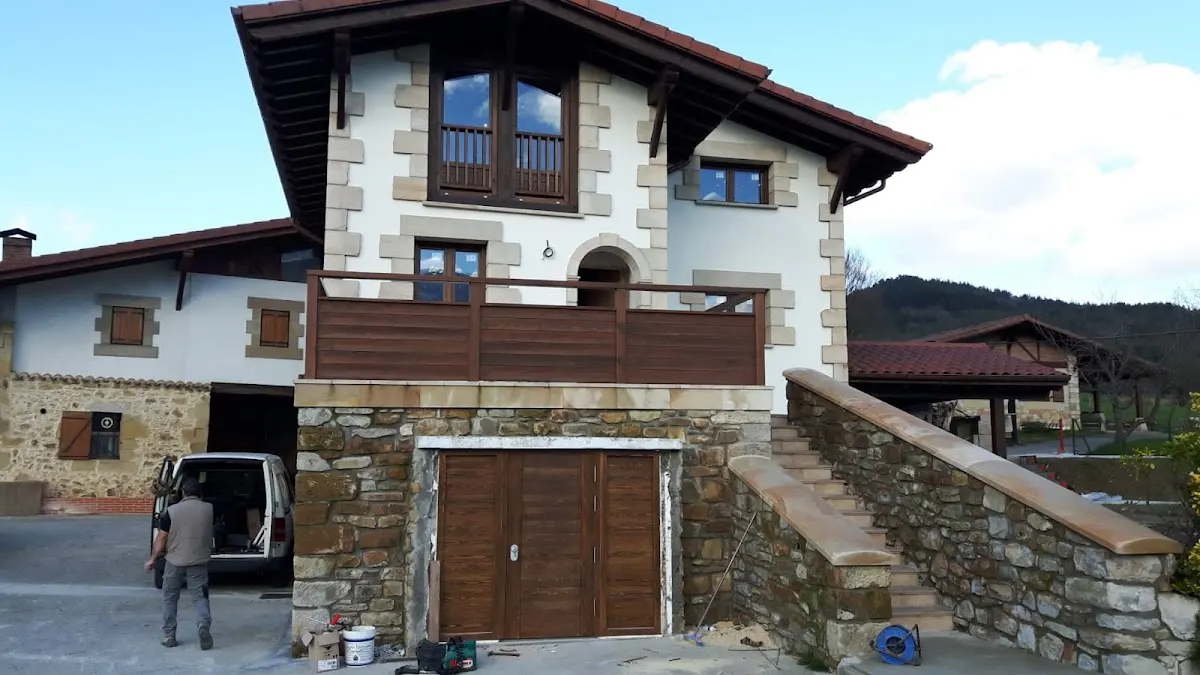 Vivienda con elementos de madera en puertas, balcón y cubierta.