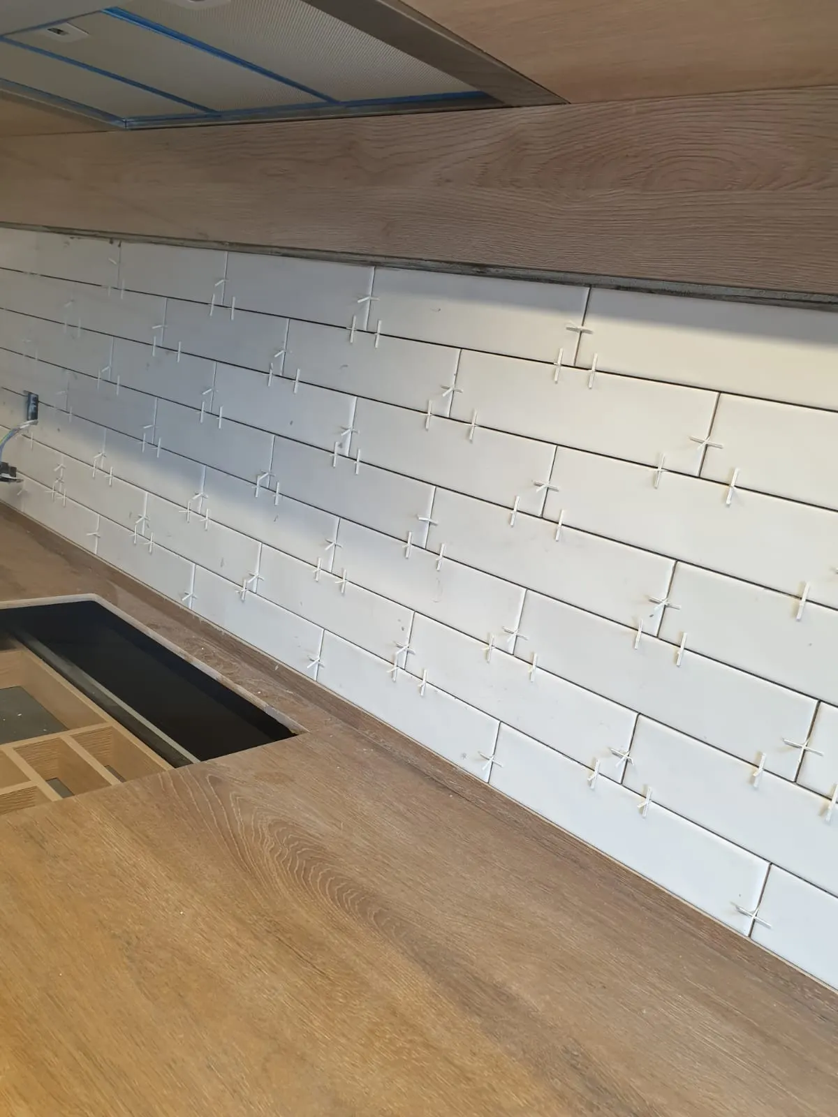 Alicatado de pared en una cocina en obra.