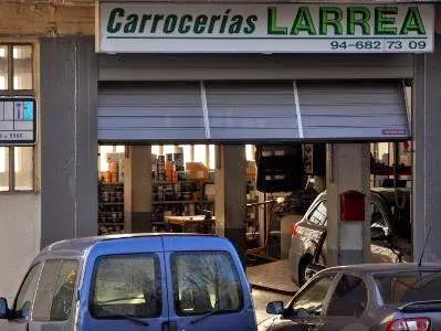 Exterior del taller Carrocerías Larrea con la persiana parcialmente abierta.