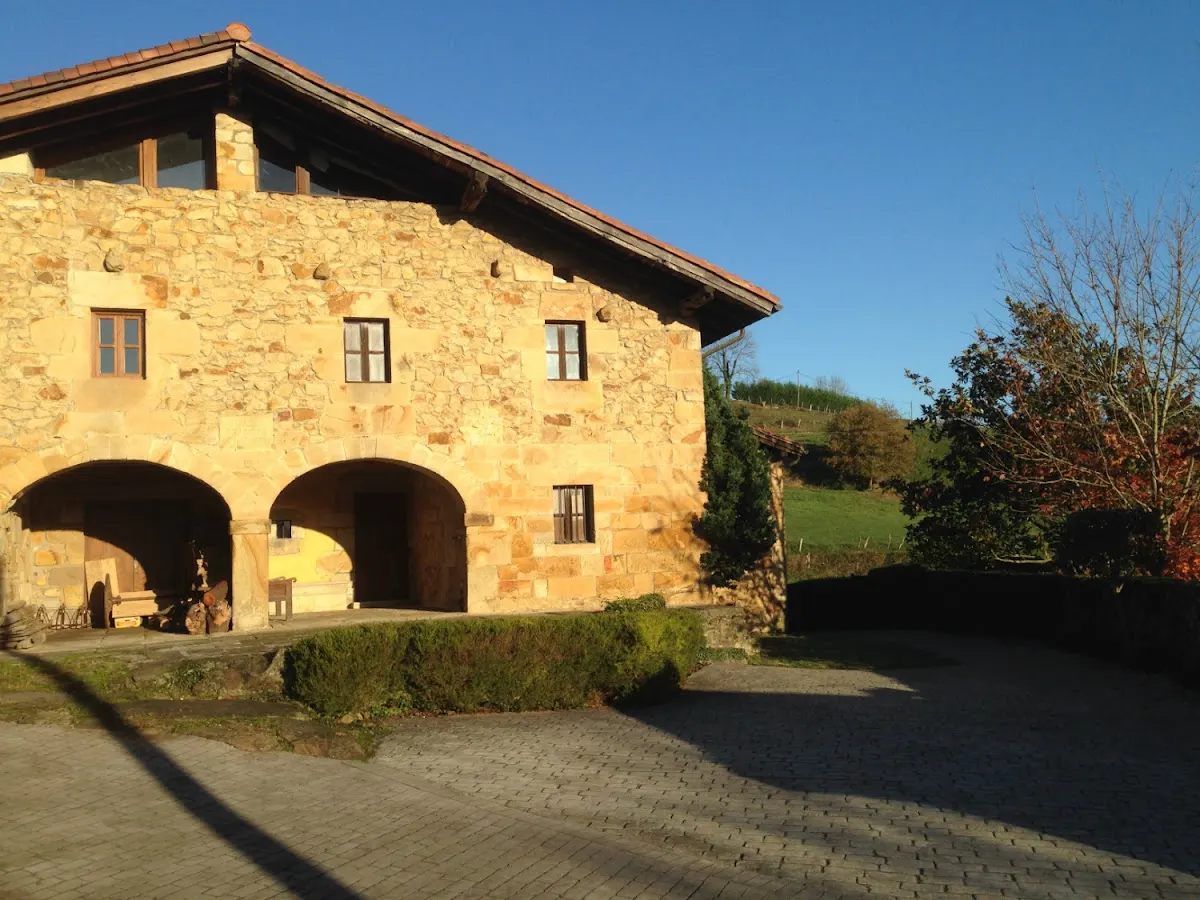 Fachada de piedra del Caserío Otalora con arcos y zona exterior