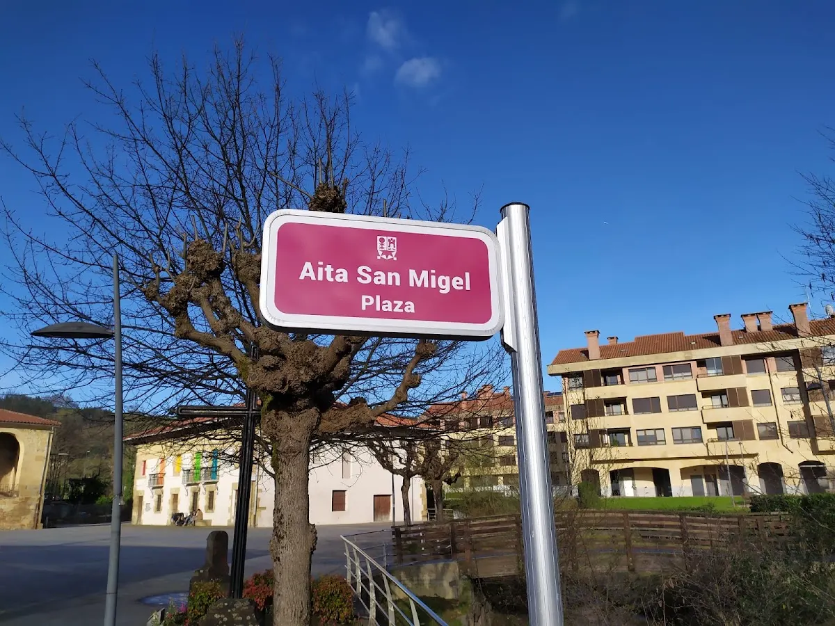 Señal de la plaza Aita San Migel en un entorno urbano de Amorebieta-Etxano.