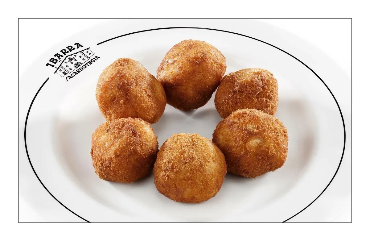 Croquetas doradas servidas en un plato de Ibarra Sagardotegia.