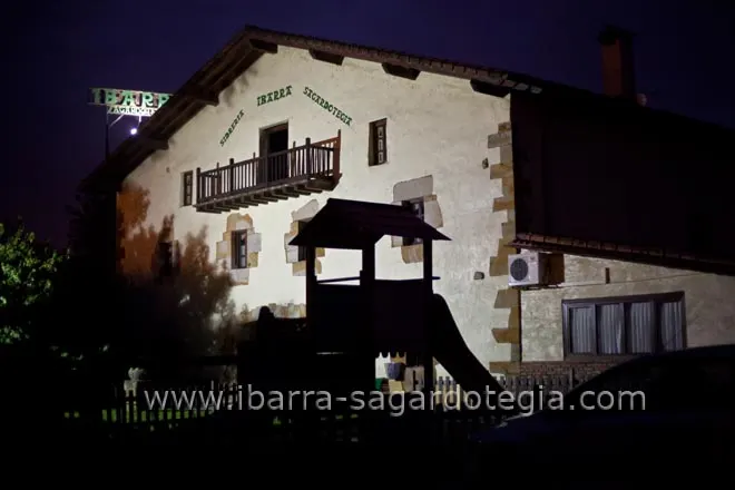 Exterior del caserío de Cervecera Sidrería Ibarra Sagardotegia iluminado de noche.