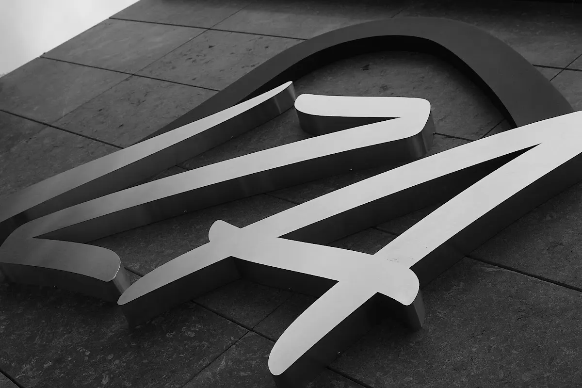 Logotipo de Clínica Dental IZA Hortz Klinika sobre un suelo de baldosas, en blanco y negro.