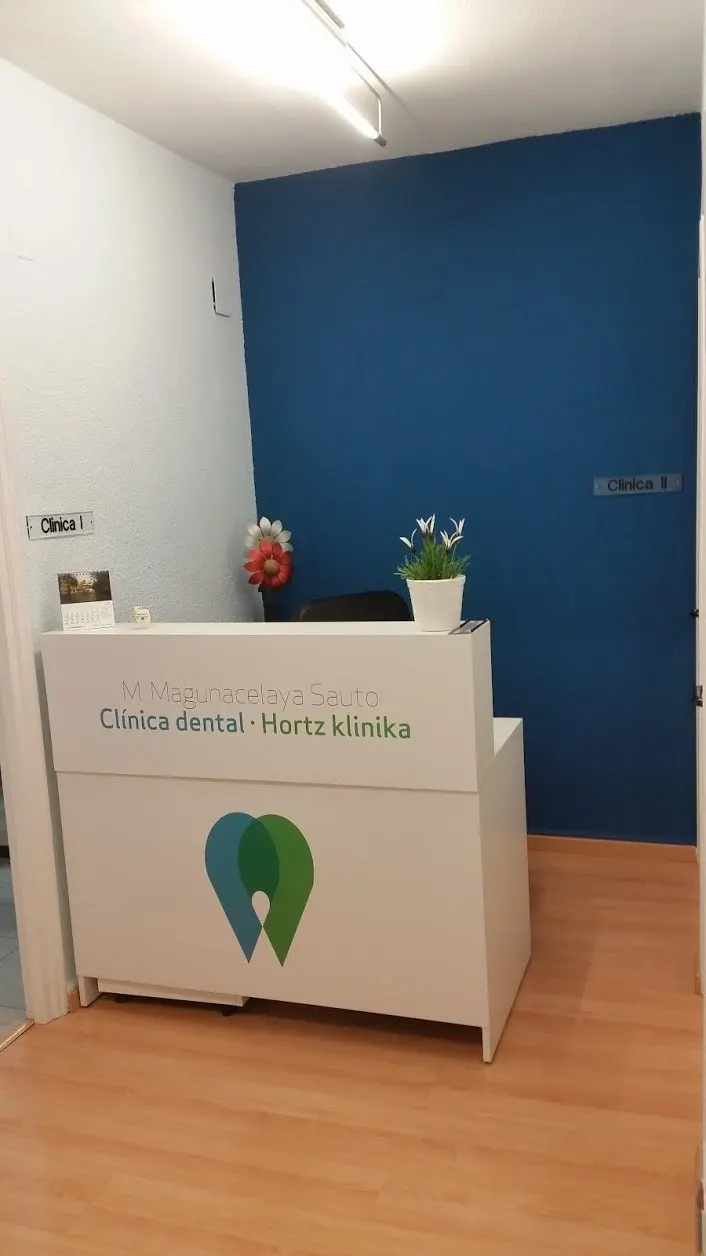 Recepción de la Clínica Dental Magunacelaya Sauto, Miriam, con mostrador y pared azul.