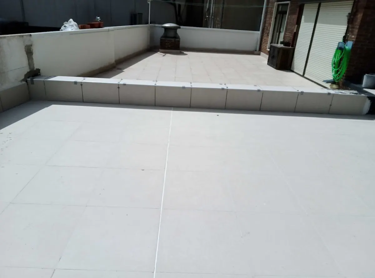 Terraza con pavimento claro y trabajos de construcción de Construcciones Holeca S.L.