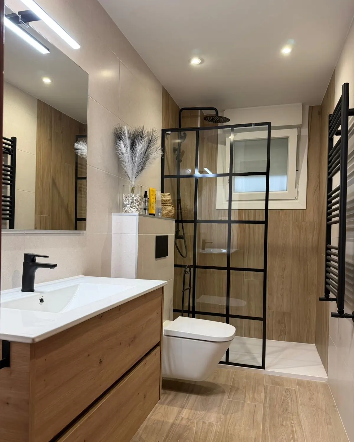 Baño reformado con mueble de madera y ducha acristalada por Construcciones Sella