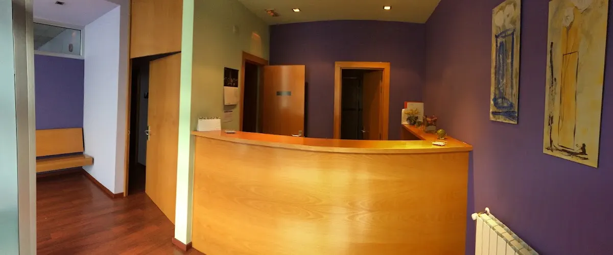 Recepción de Consulta Gihar con mostrador de madera y paredes moradas.