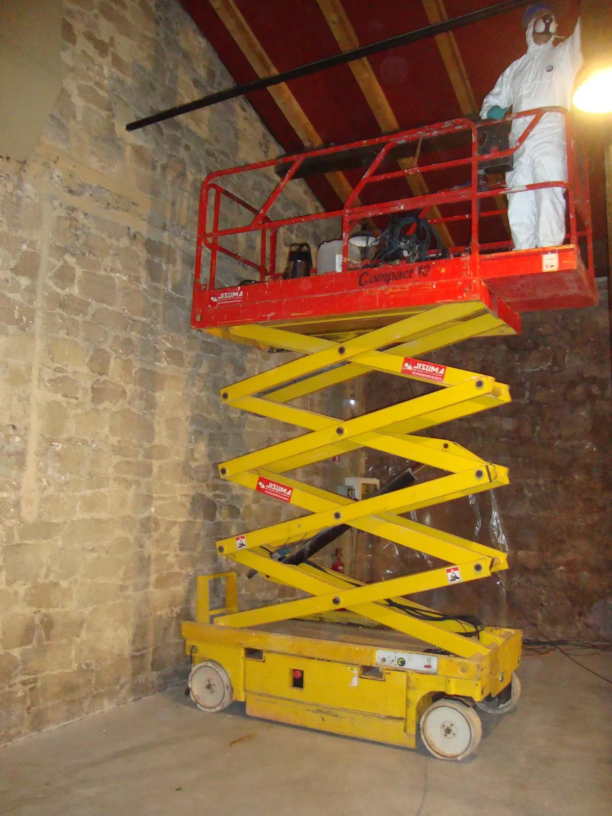 Técnico de Técnica Sanitaria trabaja con una plataforma elevadora en el interior de un edificio.