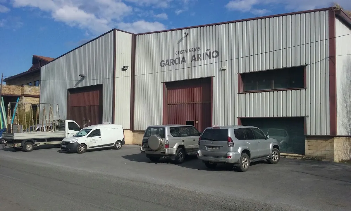 Nave de Cristalería García Ariño en Iurreta, con vehículos aparcados en el exterior.