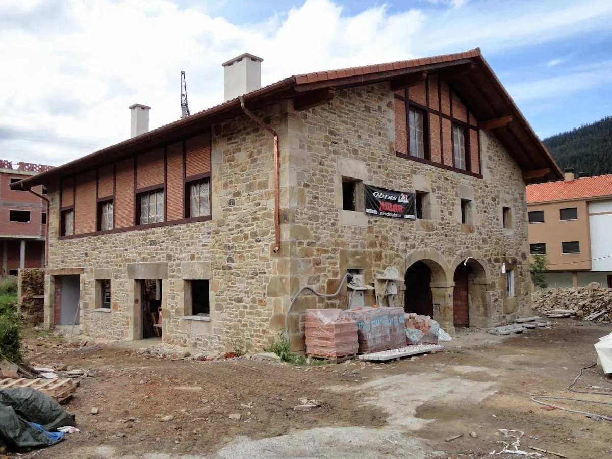Rehabilitación de una casa de piedra con andamios y materiales de obra