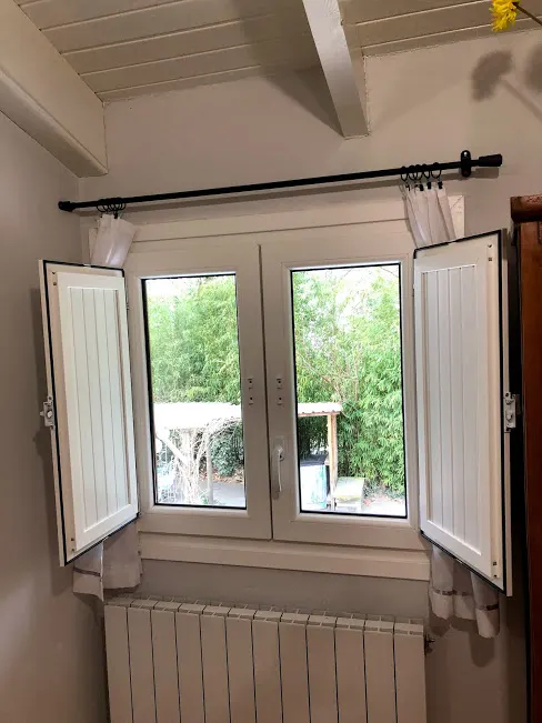Ventana instalada con contraventanas abiertas y radiador debajo