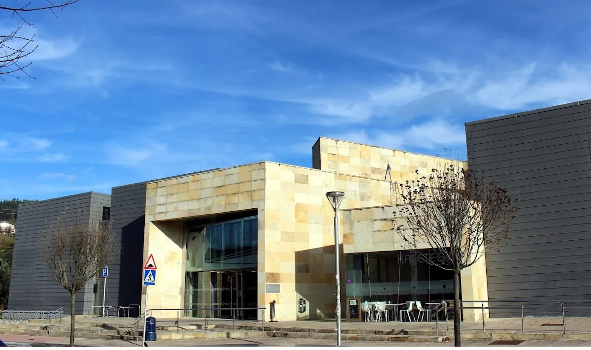 Exterior del edificio de DURANGO KIROLAK - Landako II, con fachada de piedra y entrada acristalada
