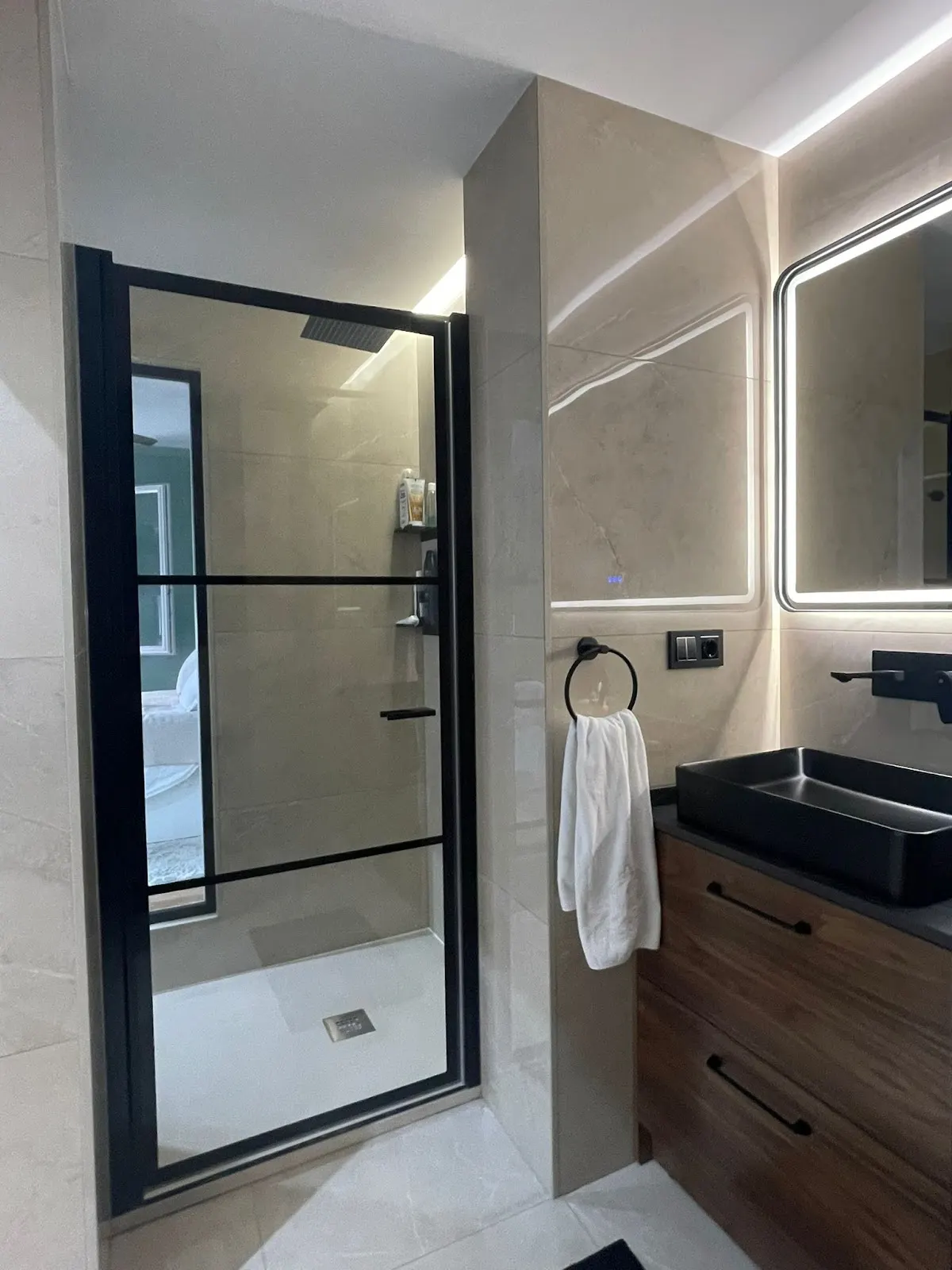 Baño con ducha acristalada y mobiliario de madera