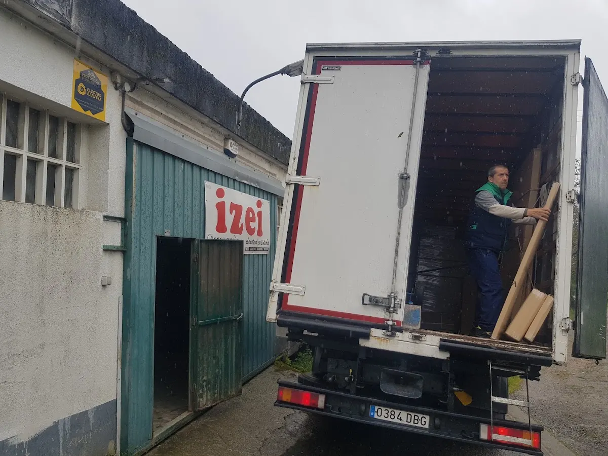 Trabajador carga piezas de madera en un camión junto al taller de IZEI en Berriz.
