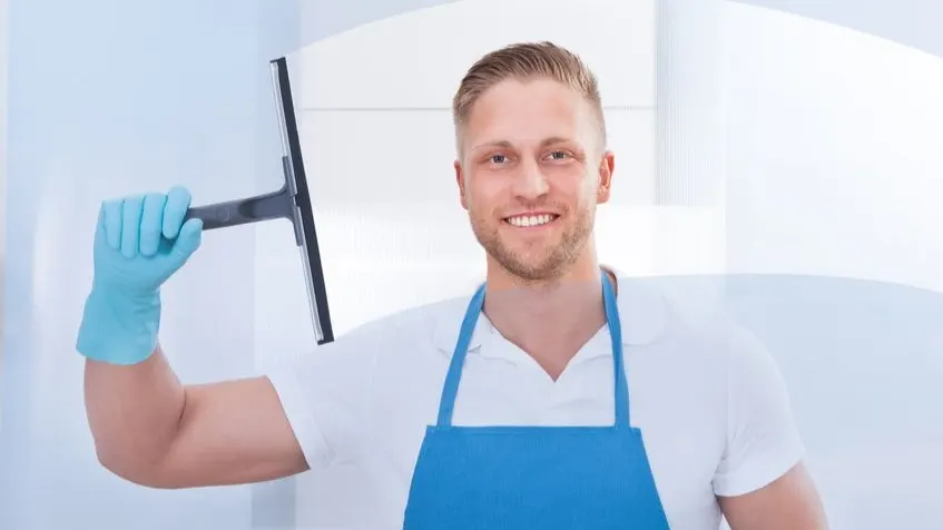 Profesional de limpieza con uniforme, guante y limpiacristales