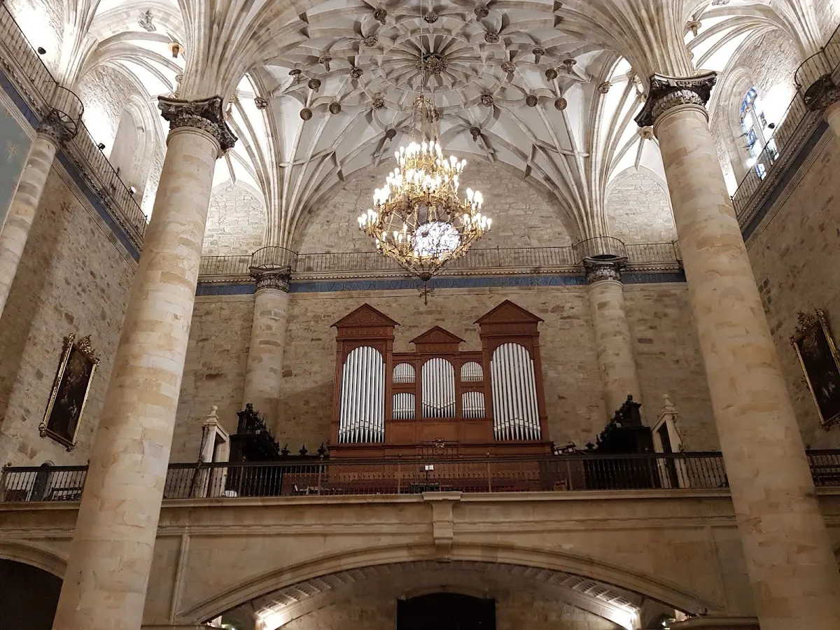 Interior de una iglesia con órgano en el coro y bóveda de piedra