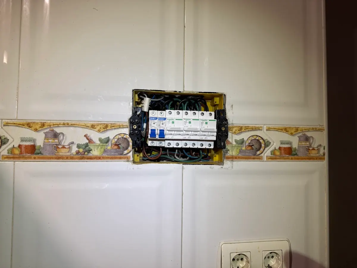Cuadro eléctrico abierto con interruptores en una pared de azulejos, trabajo de Electrimusta Euskadi