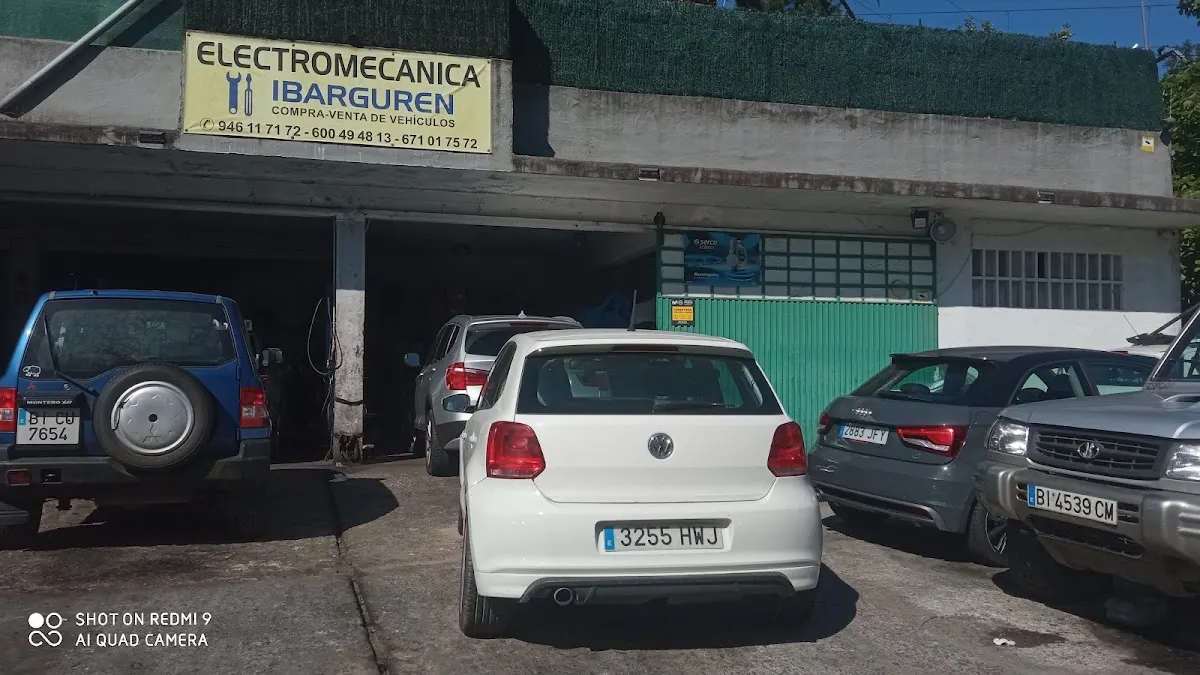 Fachada de Electromecánica Ibarguren con varios coches estacionados delante del taller