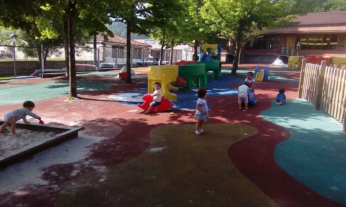 Zona de juegos exterior de Elorrioko Haurreskola, con suelo de colores y elementos infantiles.