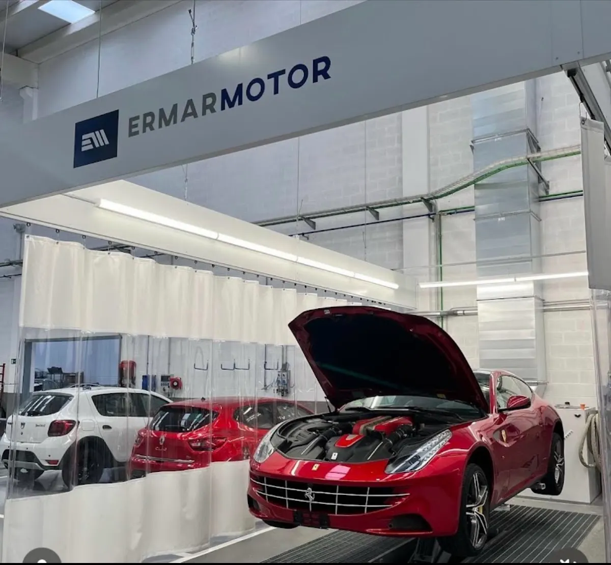Interior de Ermar Motor con un Ferrari rojo en la zona de trabajo
