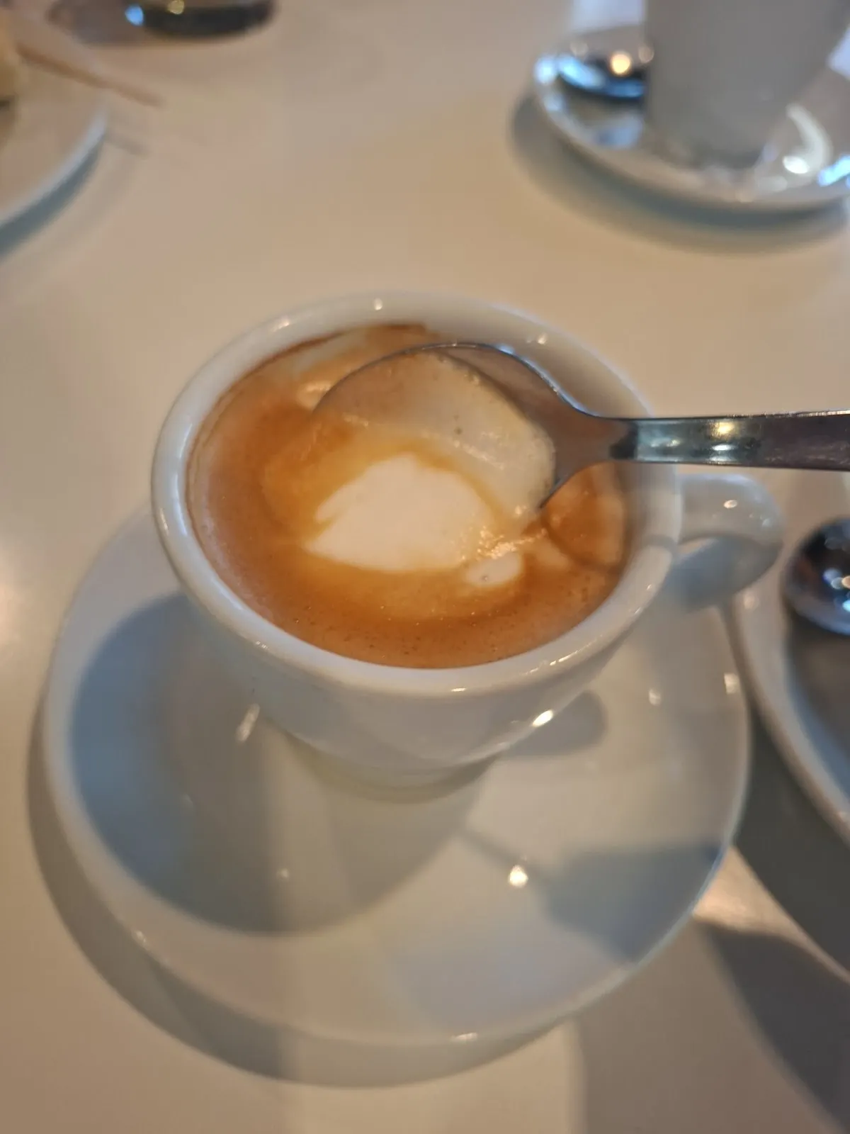 Taza de café con leche sobre un platillo