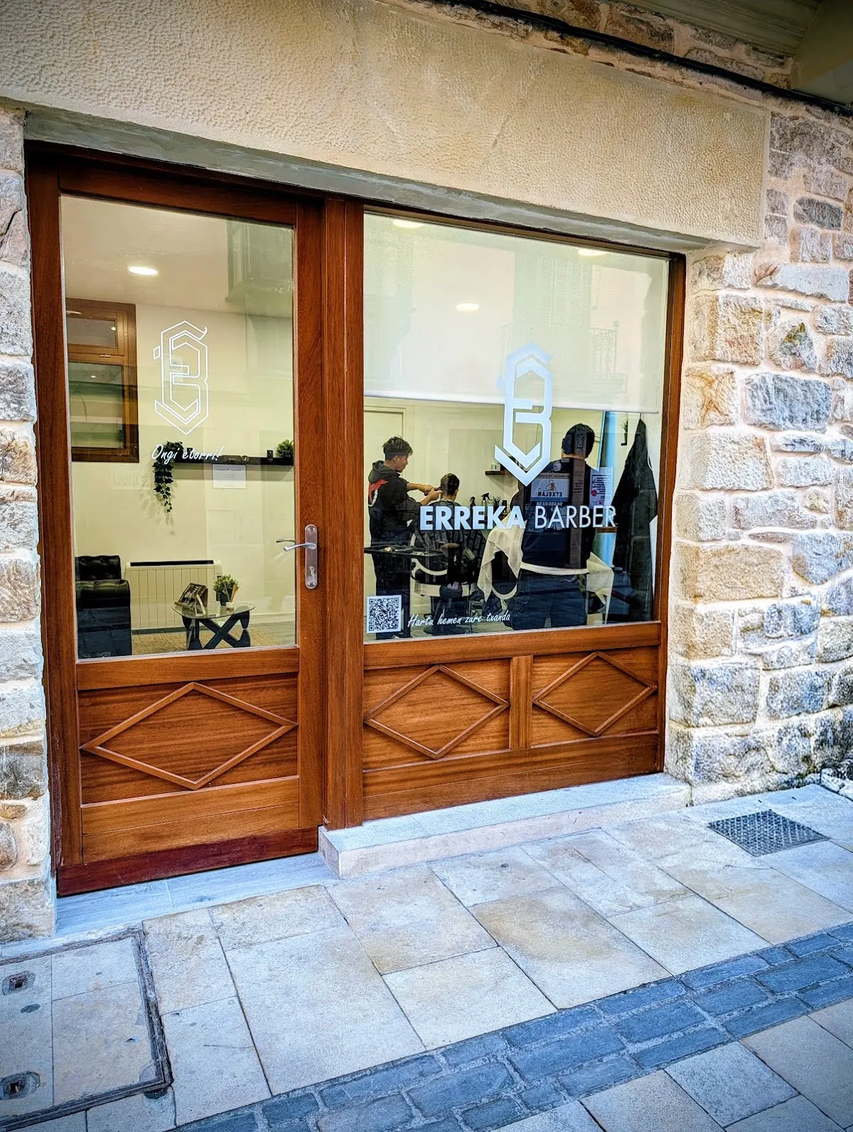 Entrada y escaparate de ERREKABARBER, con la barbería visible desde la calle.
