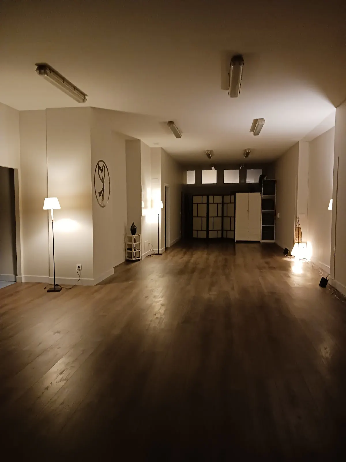 Sala amplia de Espazio Bizia con suelo de madera y luces encendidas