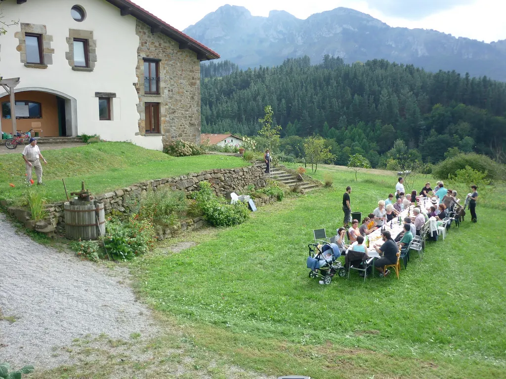Exterior de Esteñibar Baserria con una mesa larga preparada en el jardín.