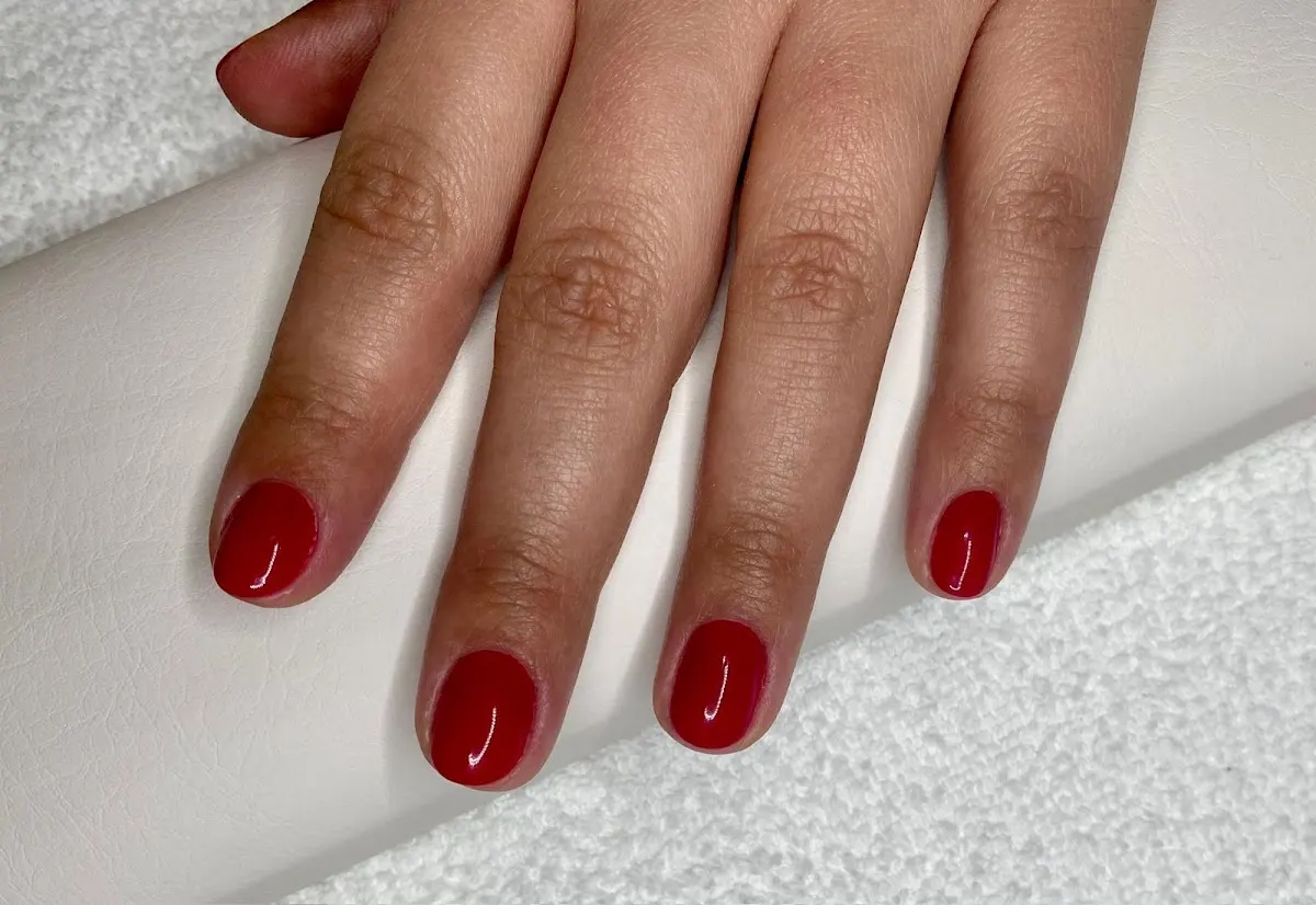 Uñas esmaltadas en rojo tras una manicura.