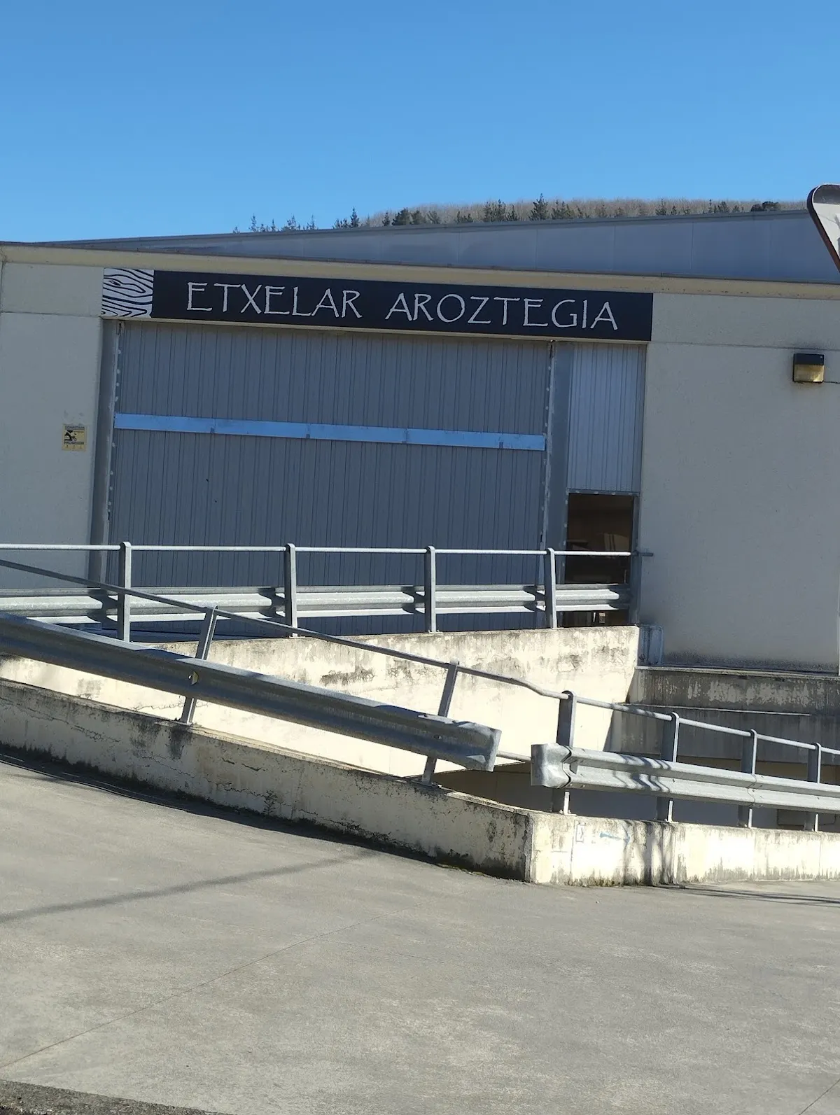 Fachada de Etxelar Aroztegia y acceso a la nave en Izurtza.