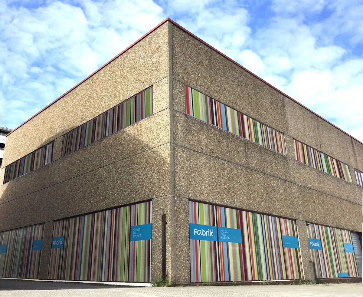 Fachada del edificio de Fabrik Color Full Events en Durango, con paneles gráficos de colores.