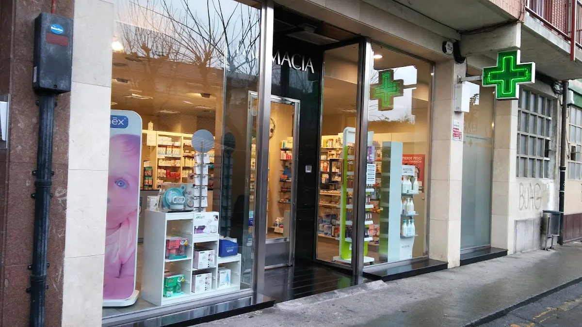 Entrada y escaparate de Farmacia López de Aretxaga, con el símbolo verde de farmacia.