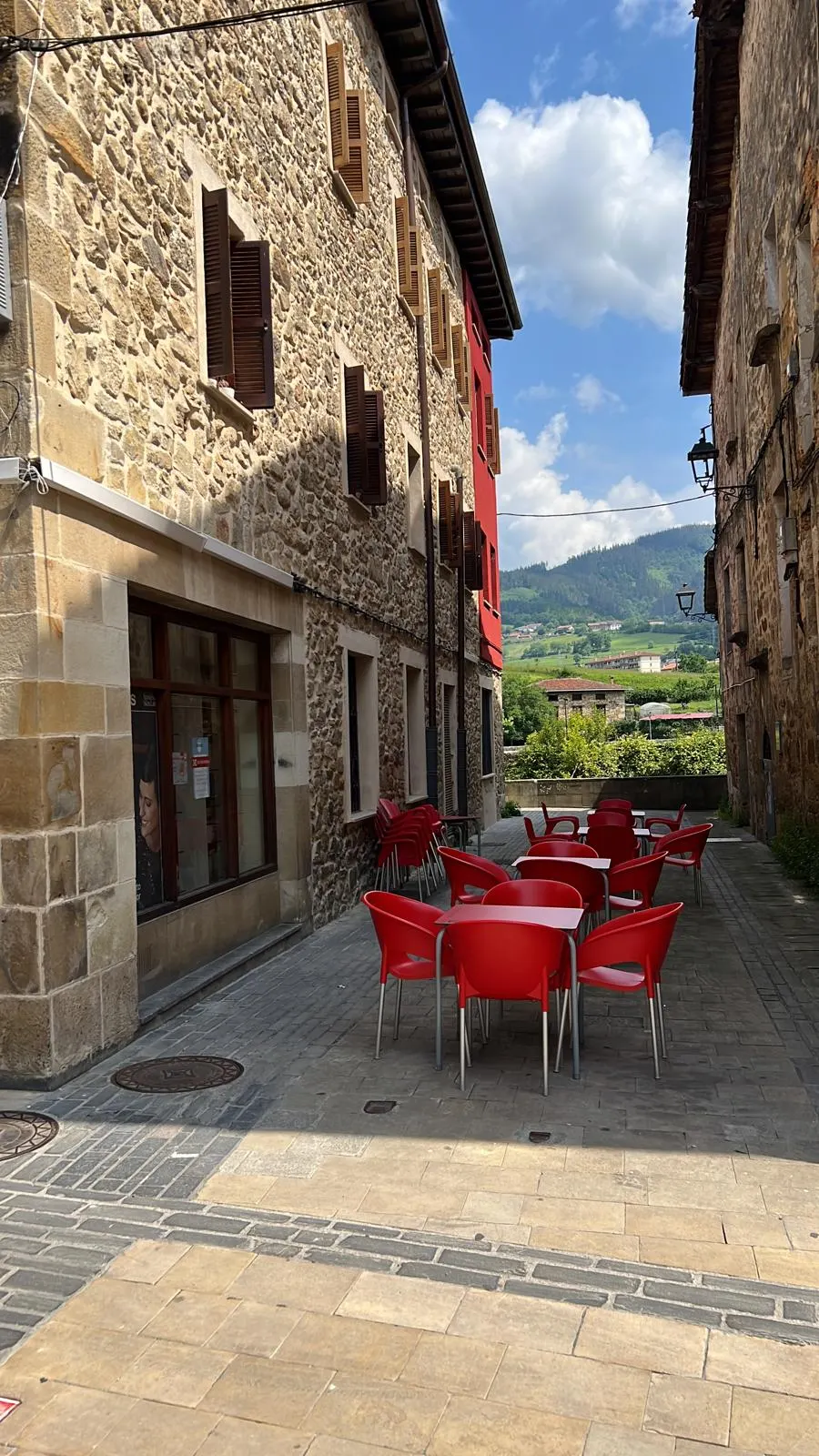 Terraza con mesas y sillas junto a un edificio de piedra en Elorrio