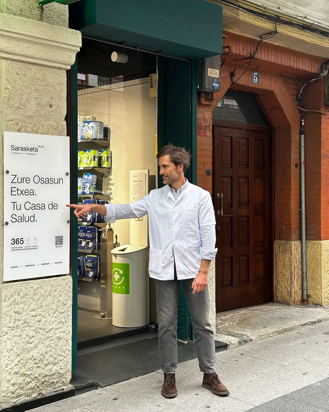 Entrada de Farmacia Sarasketa en Amorebieta-Etxano, con un profesional junto a la puerta.