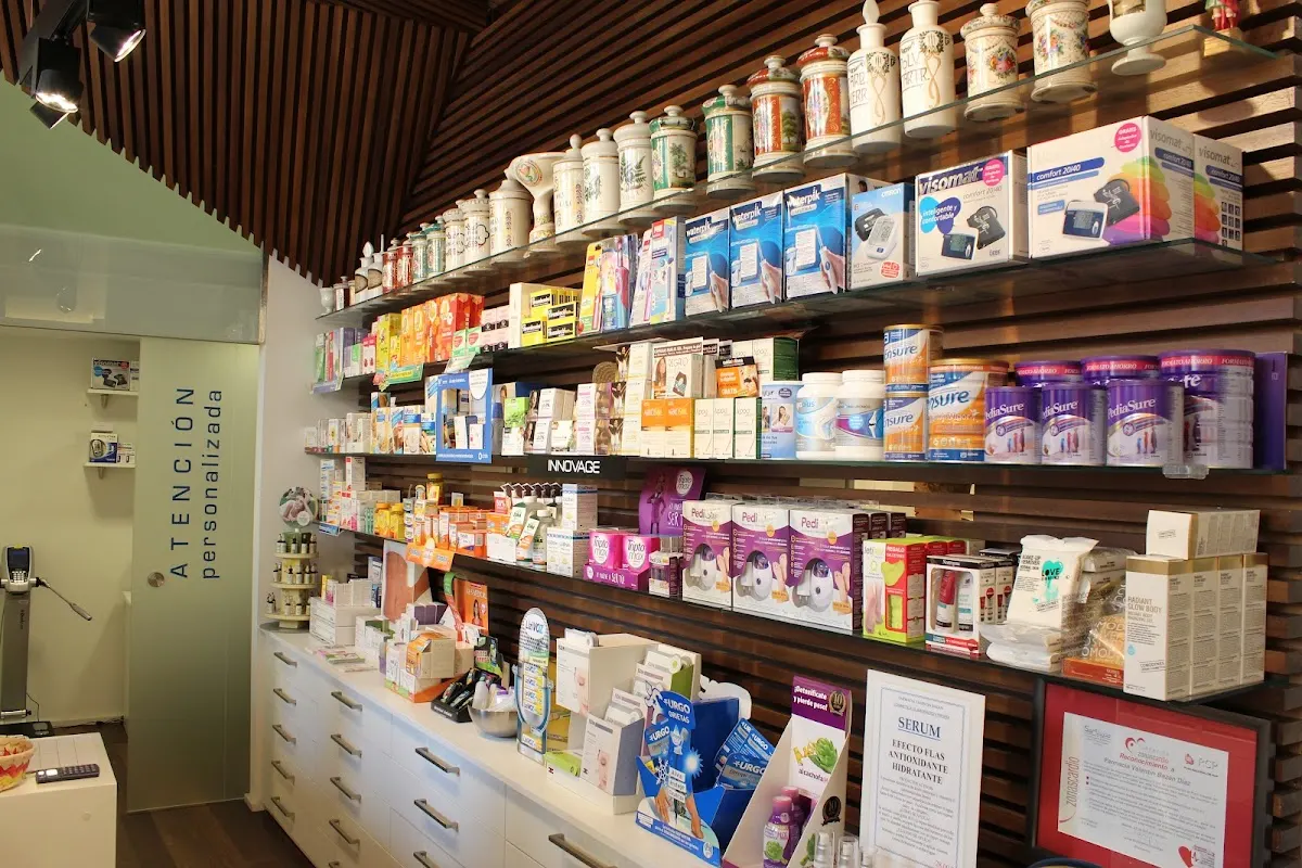 Mostrador y estanterías con productos de farmacia en la Farmacia Valentín Bazán Díaz.