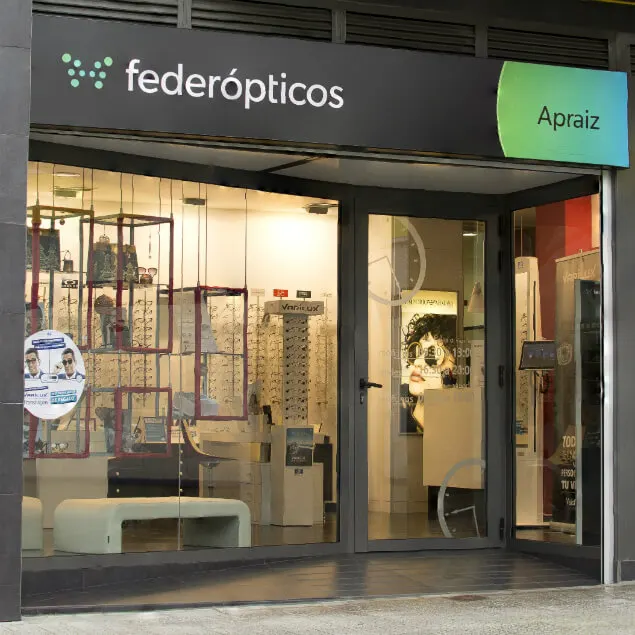 Entrada acristalada de Federópticos Apraiz y expositores de gafas en el escaparate.