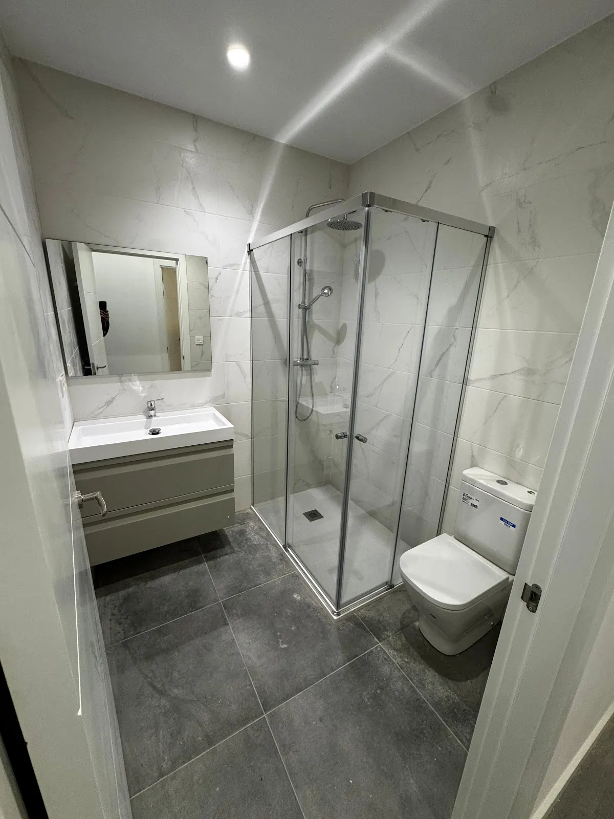Baño reformado con ducha, lavabo y revestimientos claros, trabajo asociado a FEREDU SOLUTIONS, SL.