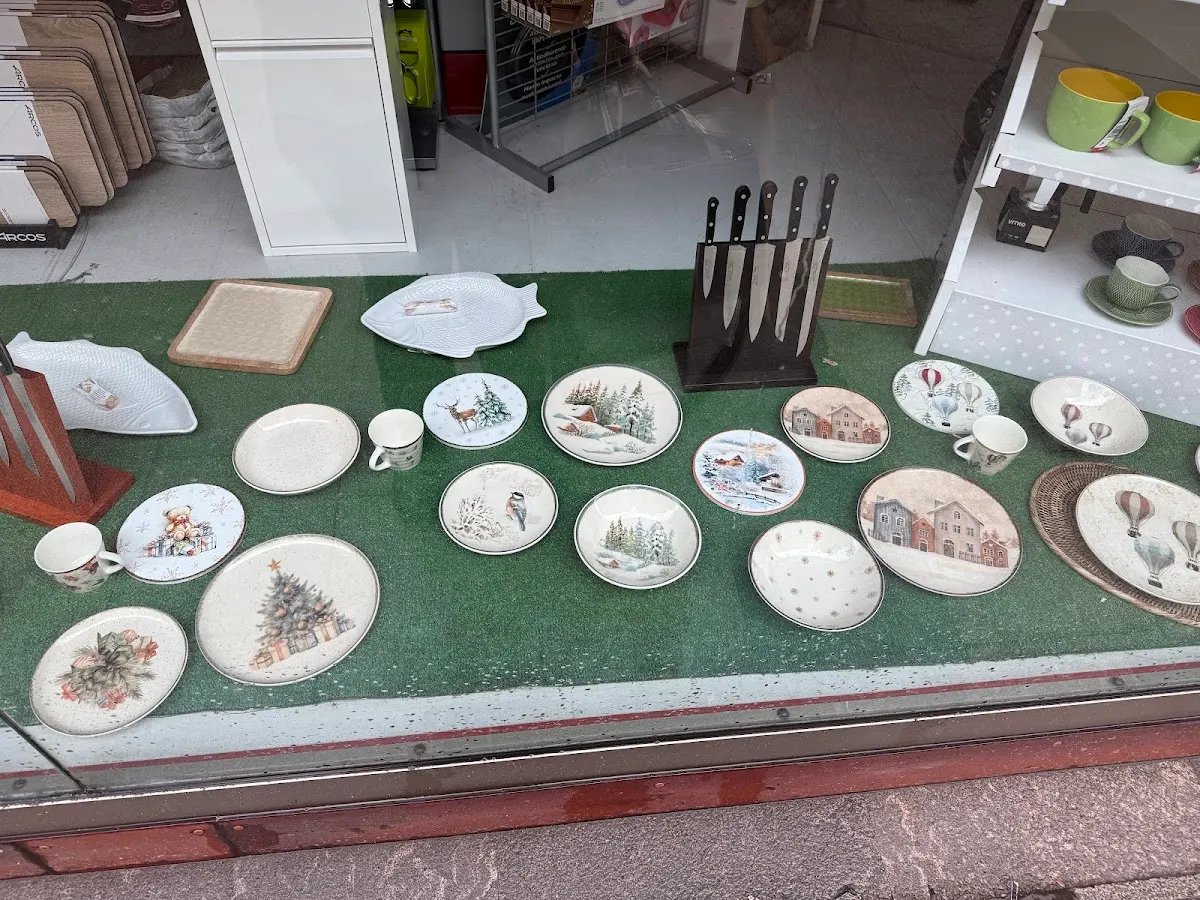 Escaparate de Ferretería Cerrajería Zornotza con vajilla, platos decorados y un juego de cuchillos.