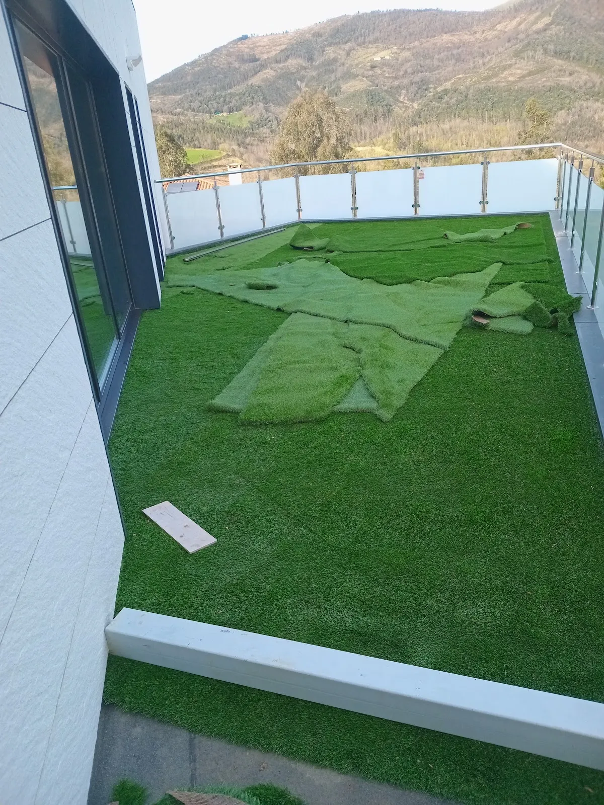 Césped artificial extendido en la terraza de una vivienda, en una imagen de Forestales y Jardinería Loois.