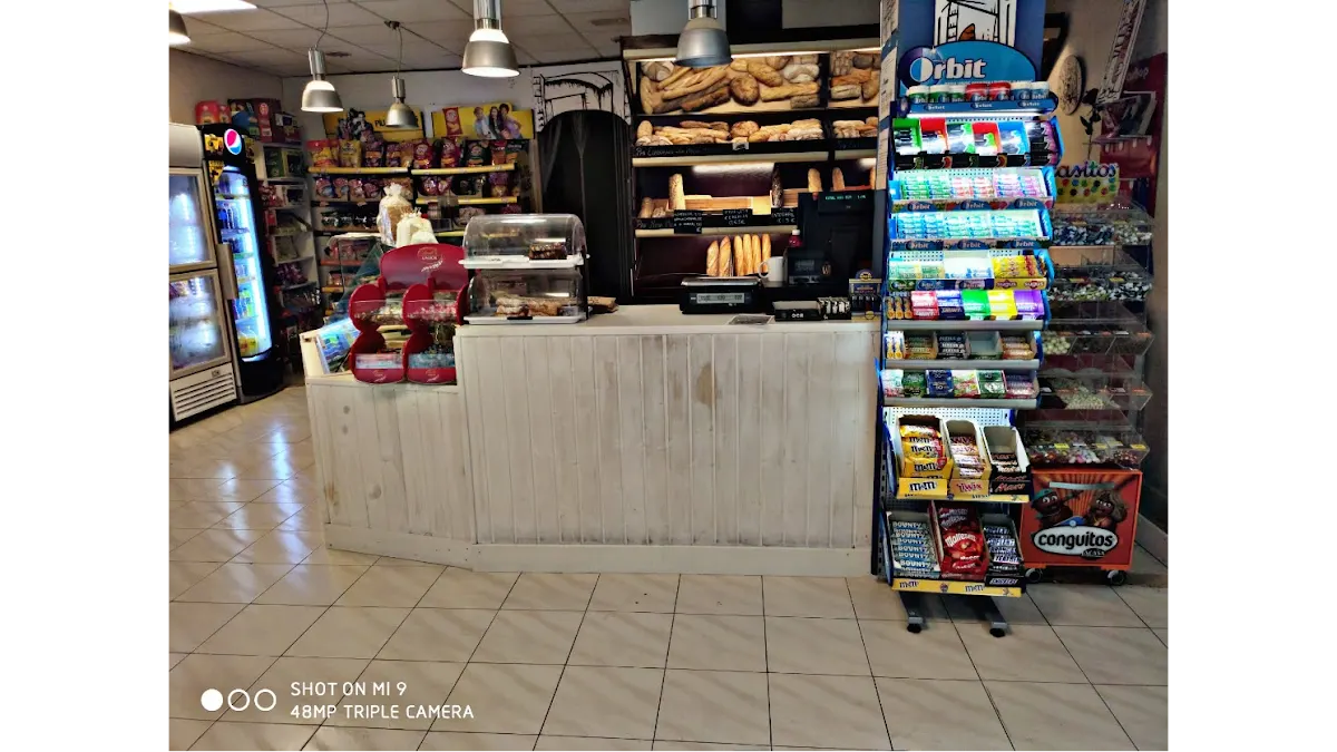Interior de Francisco Ibarra, con mostrador, productos envasados y estantes de pan.