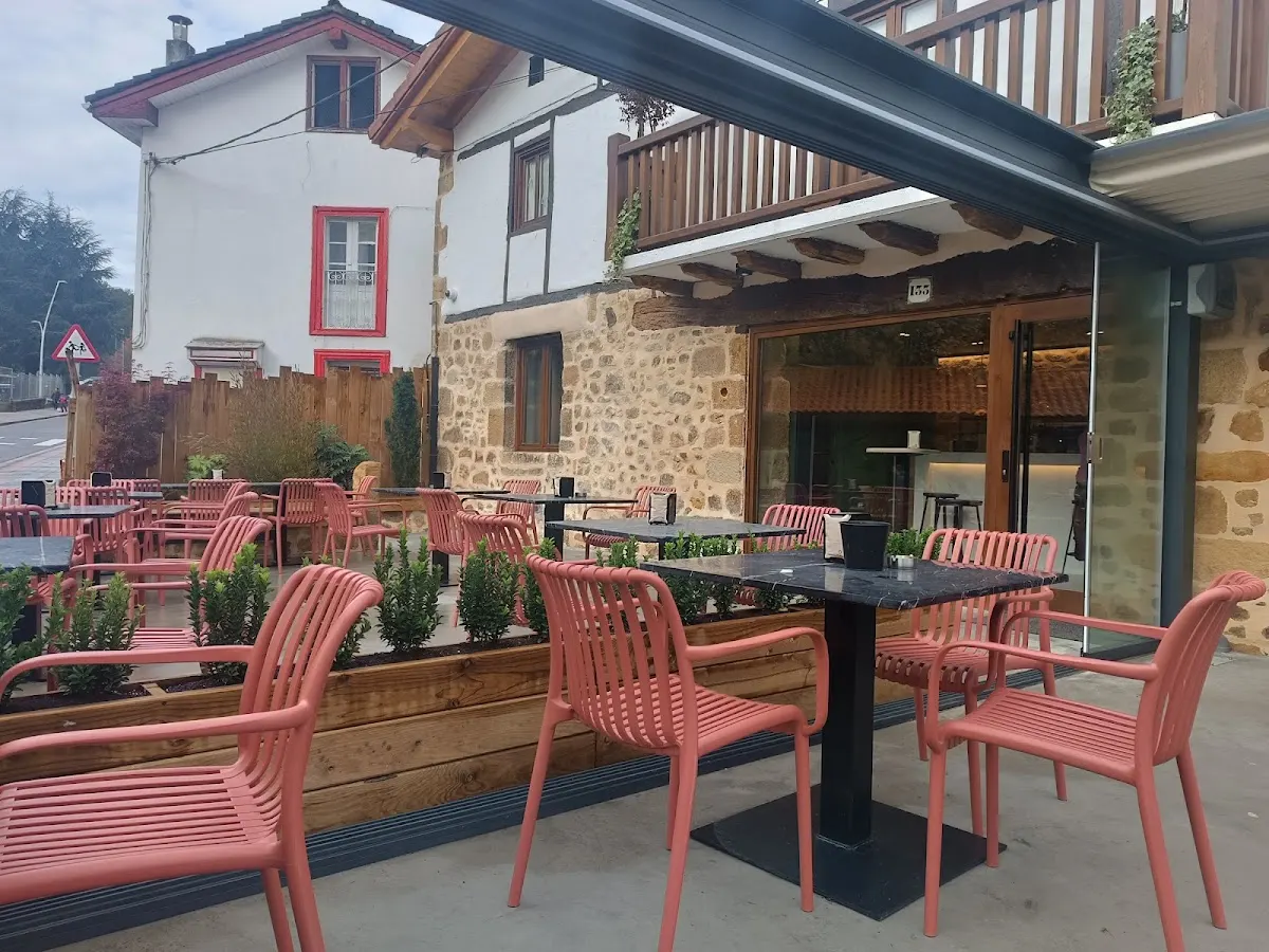 Terraza exterior de Ganeko Learreta markina, con mesas y sillas junto al edificio.