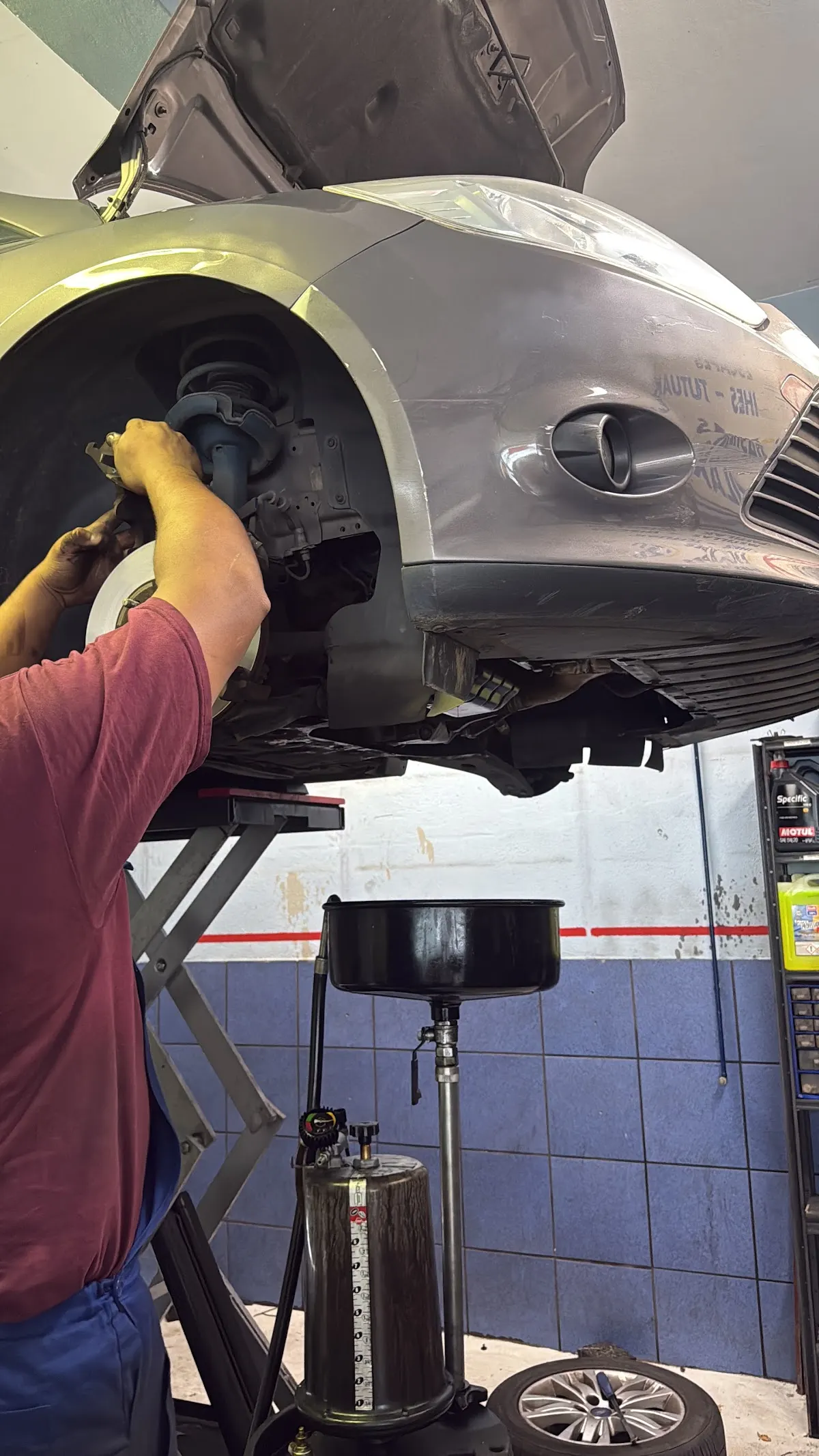 Mecánico trabajando en la rueda de un coche elevado en el taller Garage San Miguel de Iurreta.