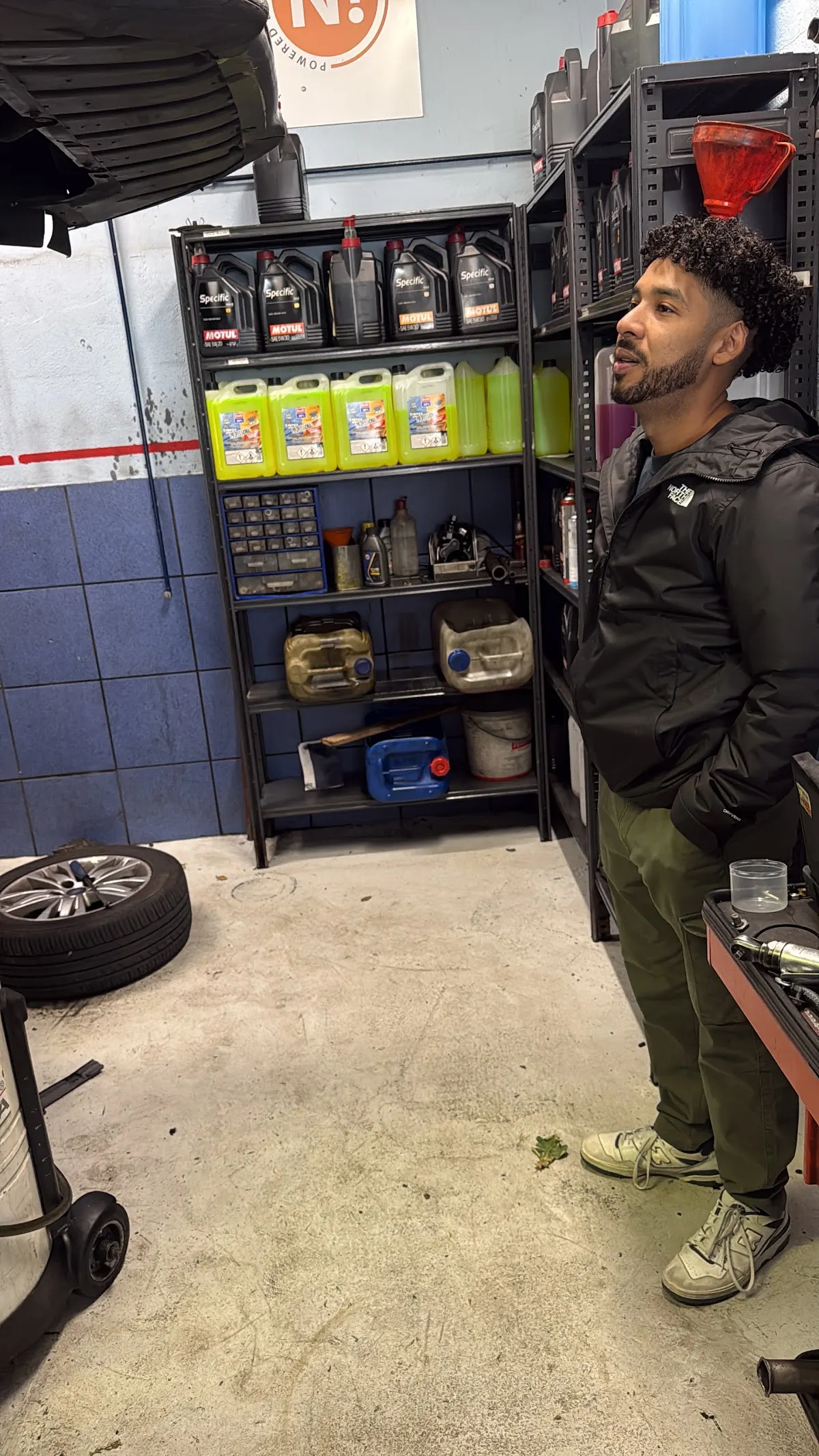 Estantería con productos de automoción y personal en el taller Garage San Miguel de Iurreta.