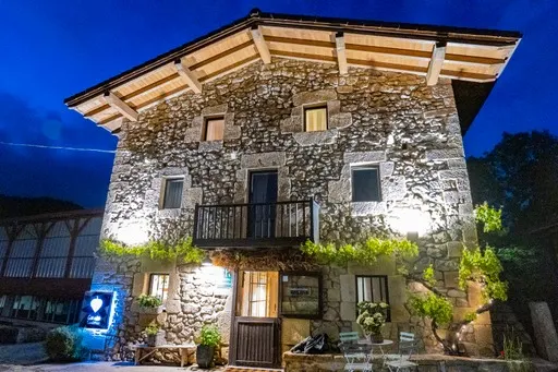 Fachada de piedra de Garaiko Landetxea iluminada al anochecer