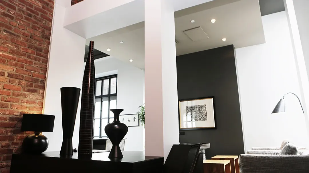 Interior de vivienda con pared de ladrillo y decoración contemporánea, imagen asociada a GAURKA.