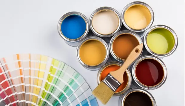 Botes de pintura de varios colores y una carta de muestras.