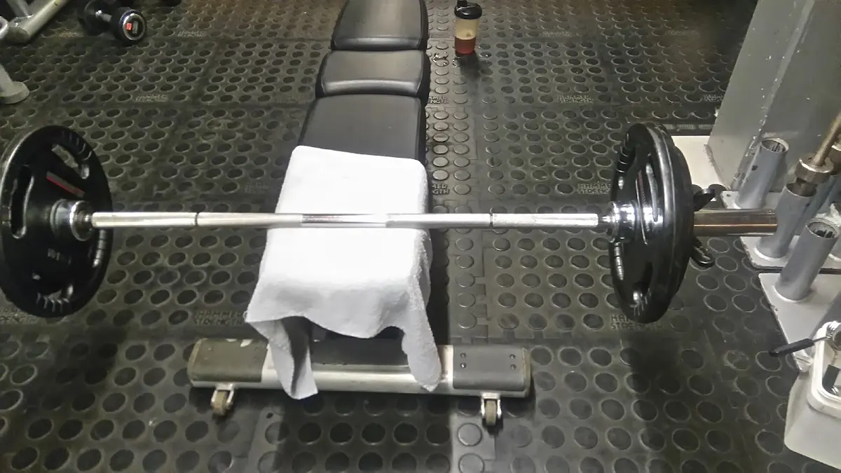 Banco de musculación con barra y discos en el Gimnasio Municipal de Durango.