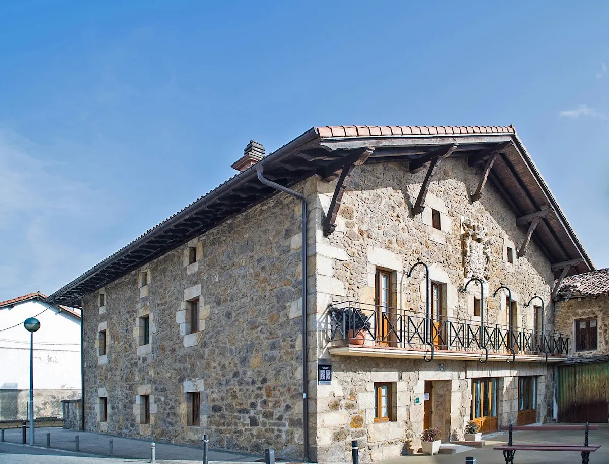 Edificio de piedra de GSR Otxandio, con balcón y tejado a dos aguas